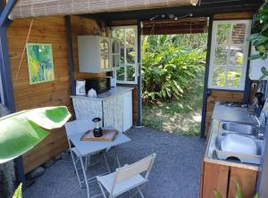 a tiny house with a sink and a table at Chez Evelyne et Thierry in Saint-Leu