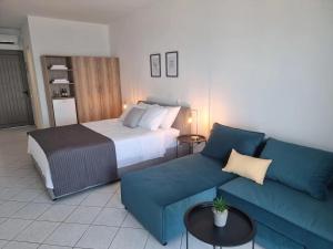 a hotel room with a bed and a couch at ThalaSea Studio - Apartments in Mytikas