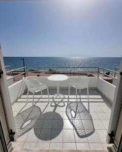 a balcony with a table and chairs and the ocean at ThalaSea Studio - Apartments in Mytikas