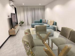 a living room with a blue couch and chairs at Blue Diamond Luxe in Gaborone