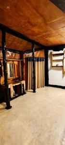 a large room with a wooden ceiling with curtains at Happybeach Sea view Cabin restaurant & beach bar in Tangalle