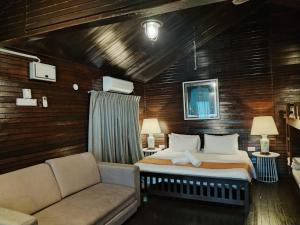 a bedroom with a large bed and a couch at Melina Beach Resort in Tioman Island