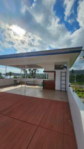 a large pavilion with a table and a bench on a deck at Triple J Villa Puerto Galera in Puerto Galera