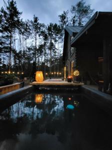 a swimming pool in front of a house at night at Nobelowka Forest SPA in Huta Podgórna