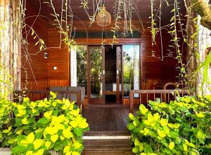 a porch with benches and plants in front of a house at Puri Melati in Uluwatu