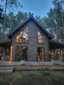 a log cabin with a deck and large windows at Nobelowka Forest SPA in Huta Podgórna