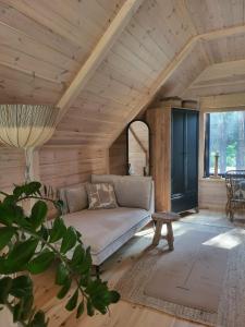 a living room with a couch in a wooden room at Nobelowka Forest SPA in Huta Podgórna +65 photos