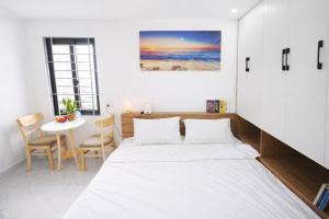 a bedroom with a bed and a table with chairs at Green West Lake Residence in Hanoi