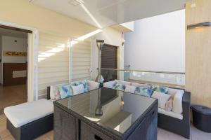 a living room with a glass table and couches at August Villa Málaga. Relax Playa Piscina Coworking in Málaga