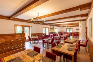 a restaurant with wooden tables and red chairs at Club del Sole Val di Fiemme Easy Camping Village in Bellamonte