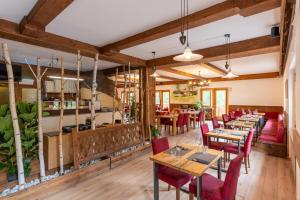 a restaurant with wooden tables and red chairs at Club del Sole Val di Fiemme Easy Camping Village in Bellamonte +61 photos