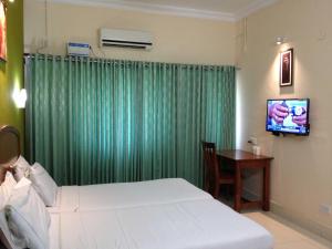 Hotel Nandanam tesisinde bir odada yatak veya yataklar