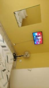 a room with a bed and a tv on the wall at METINAT GUEST HOUSe in Groblersdal