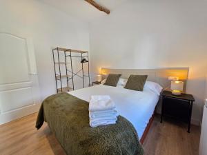 a bedroom with a bed with towels on top of it at El Rincón de Santa Eufemia in Ourense