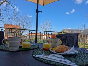 a table with two plates of food and two cups of orange juice at Animo House in Pianillo