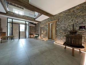 a large room with a stone wall and a table at Elizetxea in Larceveau-Arros-Cibits