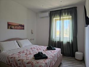 a bedroom with a bed with two black shoes on it at Animo House in Pianillo