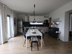 a dining room and kitchen with a white table and chairs at Lipnohaus in Horní Planá