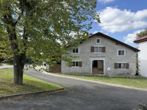 an old stone house with a tree next to a road at Elizetxea in Larceveau-Arros-Cibits