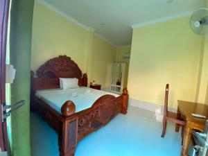 a bedroom with a wooden bed in a room at Pov Monique 2 in Stœ̆ng Trêng