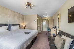 a hotel room with a large bed and a couch at The Throckmorton in Alcester