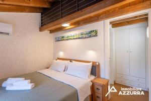 a bedroom with a bed with towels on it at Aly d'Angelo alla Torre - Immobiliare Azzurra in Bardolino