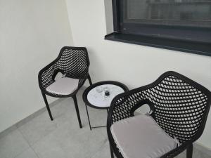two chairs and a table in a room at Apartman Milos in Modriča