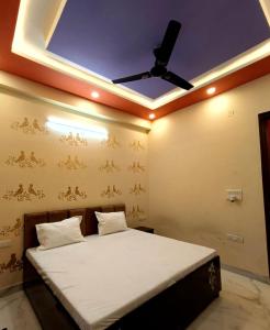 a bedroom with a bed with a ceiling fan at Fng Guest House in Noida
