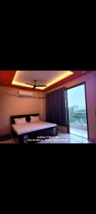 a bedroom with a bed and a large window at Fng Guest House in Noida +3 photos