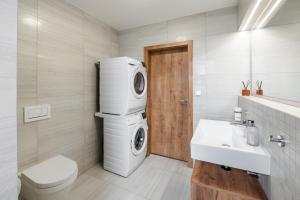 a bathroom with a washing machine and a sink at Apartmány Lošov in Olomouc +41 photos