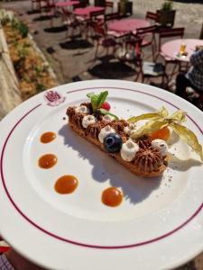 a dessert on a white plate on a table at HOTEL DE L'ABBAYE DE LONGPONT in Longpont