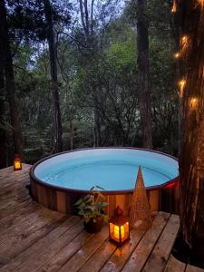 a jacuzzi tub on a wooden deck with lights at Fantail Bush Chalet and Hot Tub in Parakakau