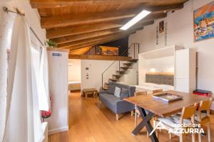 a dining room and living room with a table and a couch at Aly d'Angelo alla Torre - Immobiliare Azzurra in Bardolino