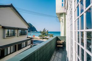 a balcony of a building with a view of the ocean at Coucou House Gra in Toyooka