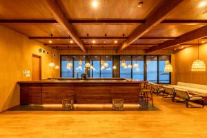 a bar in a large room with chairs and tables at Ishinoya Beppu - TKP Hotels & Resorts in Beppu