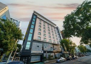 a large building on a city street with cars parked at Browndot Hotel Daegu Exco branch in Daegu