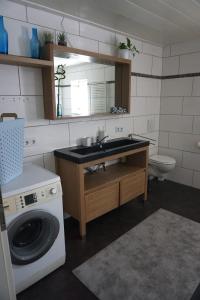 a bathroom with a sink and a washing machine at Leuchtturmnest in Krummhörn