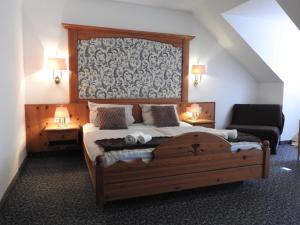a bedroom with a large wooden bed and a couch at Hotel Argo Lindau in Lindau