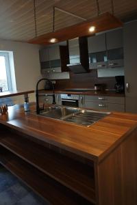 a kitchen with a sink and a wooden counter top at Leuchtturmnest in Krummhörn +14 photos