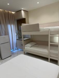 a room with two bunk beds and a refrigerator at Xhelilaj Rooms in Vlorë