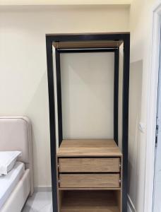 a closet with a wooden dresser next to a bed at Xhelilaj Rooms in Vlorë