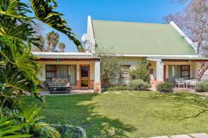 a house with a green roof and a yard at HOSPITALity Lodges in Johannesburg