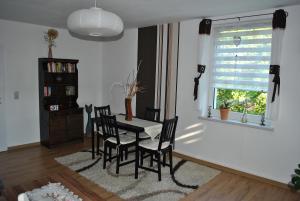 a dining room with a table and chairs and a window at Ferienwohnung Thiedmann in Hagebök +16 photos