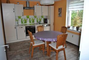 a kitchen with a purple table and chairs at Ferienwohnung Thiedmann in Hagebök