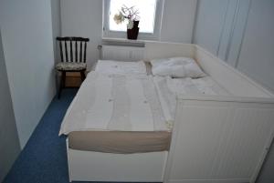 a white bed in a small room with a window at Ferienwohnung Thiedmann in Hagebök
