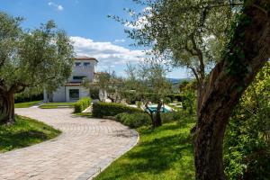 a brick walkway in front of a house with trees at VILLA MANDARA 8&2, Emma Villas in Misano Adriatico