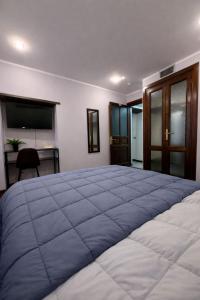 a bedroom with a large bed with a blue blanket at FRASCATI Suites in Frascati