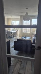 a living room with a couch and a table at Duinzicht, ruim appartement met terras op de begane grond nabij strand in Buren