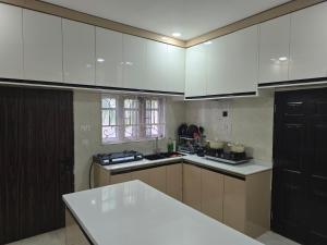 a kitchen with white cabinets and a white counter top at House 27 in Idu