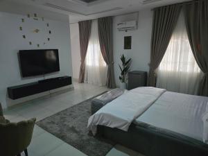 a bedroom with a bed and a flat screen tv at House 27 in Idu